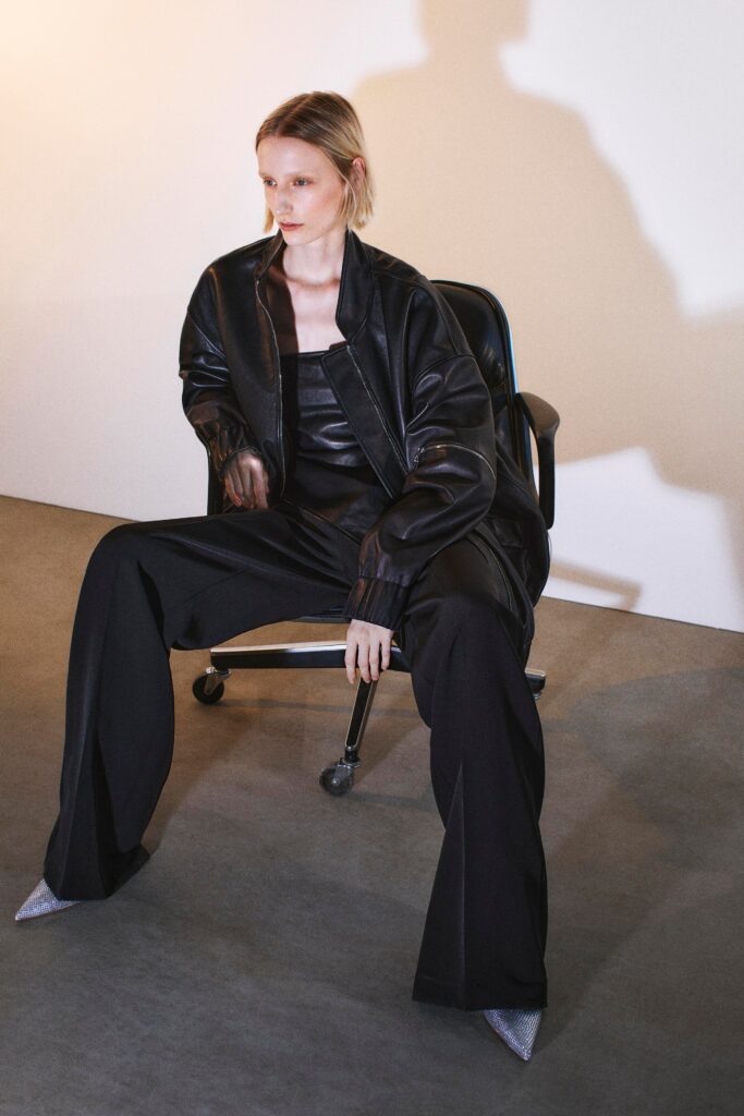 A relaxed black leather jacket paired with wide-leg black pants for a chic look.