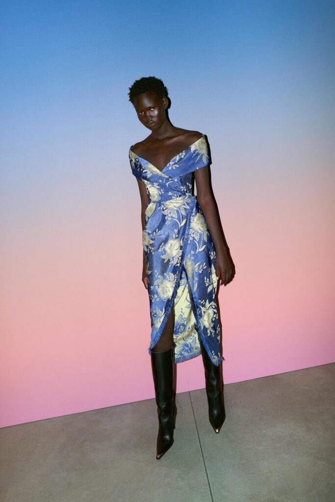 A fitted blue and yellow floral silk off-shoulder dress with a flared silhouette.