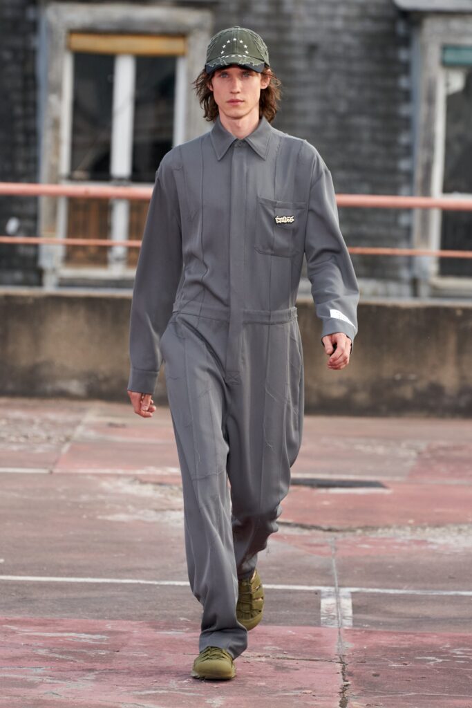 A relaxed gray cotton jumpsuit with long sleeves and a zippered front.