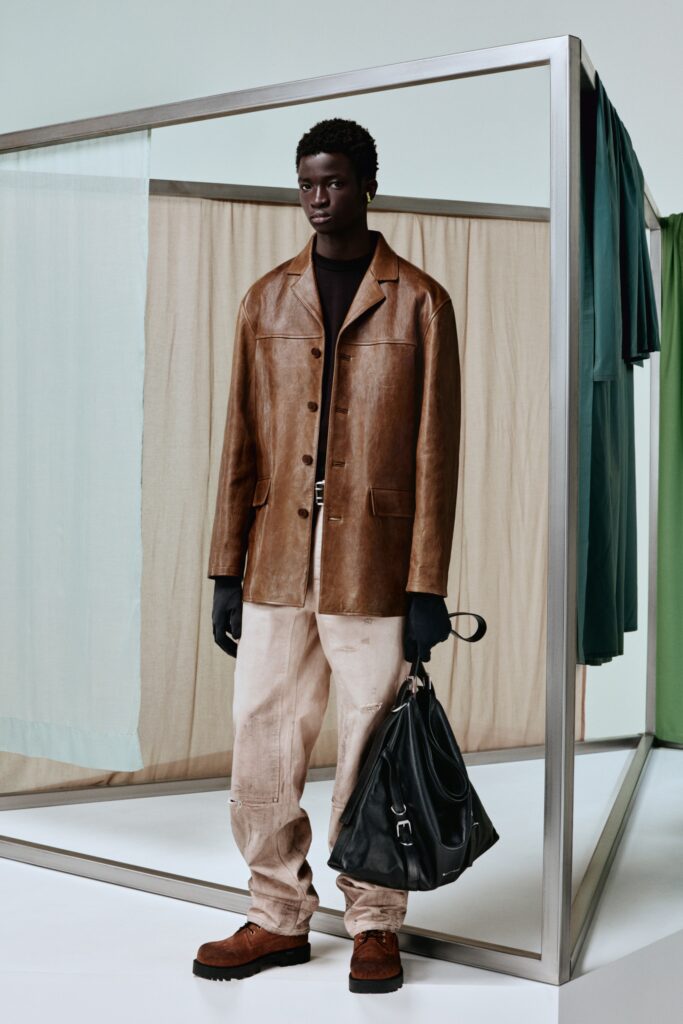 A relaxed brown leather jacket paired with high-waisted beige pants, featuring a collared design.