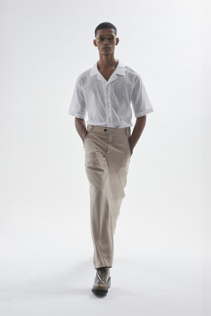 A relaxed white cotton short-sleeve shirt paired with straight-leg beige pants.