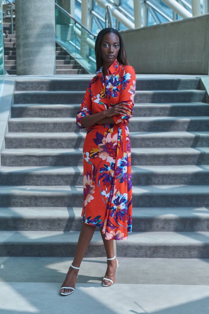 A fitted red dress with long sleeves, a collared neckline, and a floral design.