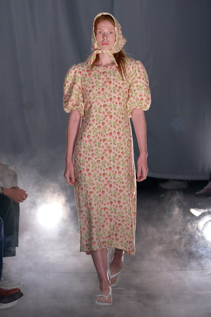 A relaxed cream dress with short sleeves and a high neckline featuring a floral pattern.