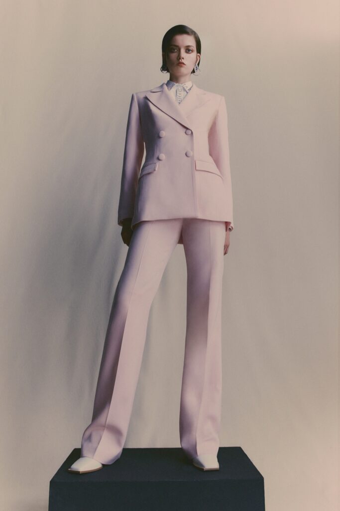 A tailored pink suit with long sleeves and a collared shirt, featuring straight-leg pants.