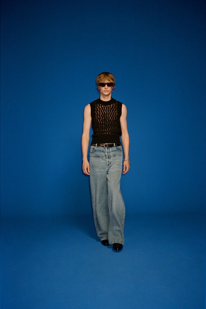 A relaxed black sleeveless top paired with wide-leg blue jeans for a casual look.