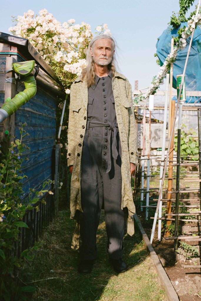 A relaxed gray cotton coat layered over a jumpsuit with long sleeves and a collared design.