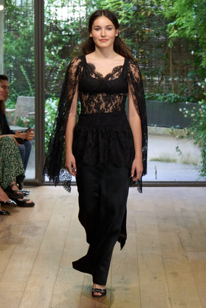 A fitted black lace dress with a V-neckline and layered design details.