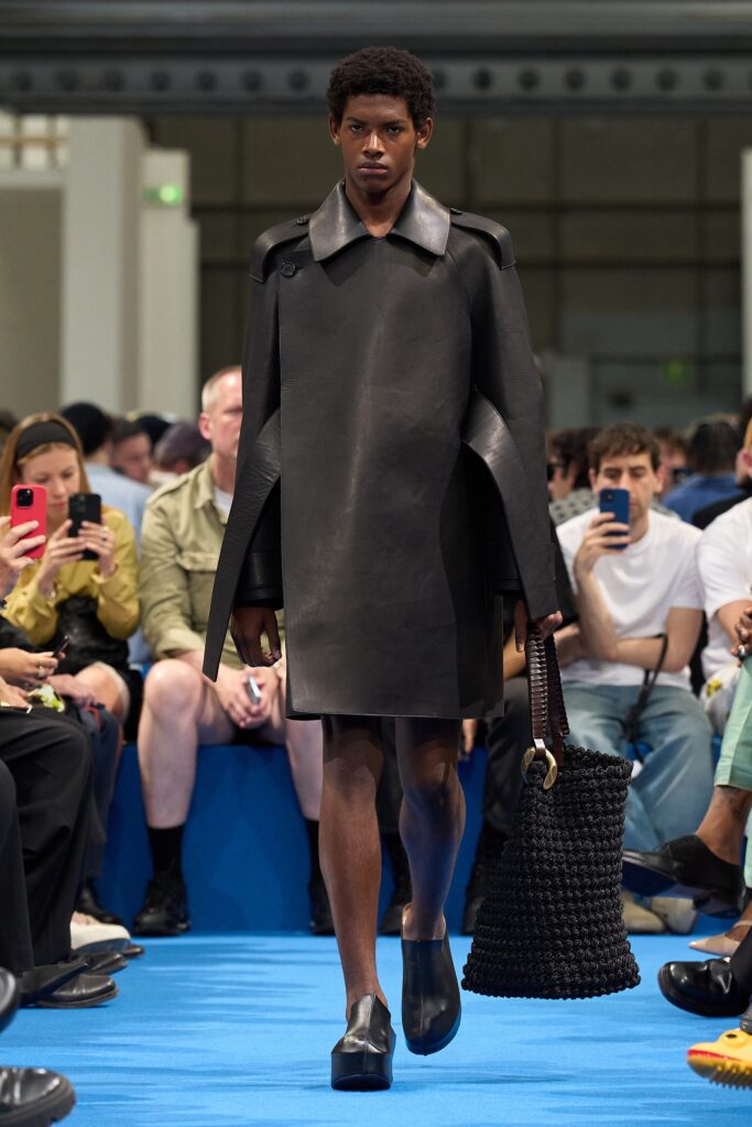 A relaxed black leather sleeveless dress with a high neckline and straight-leg silhouette.