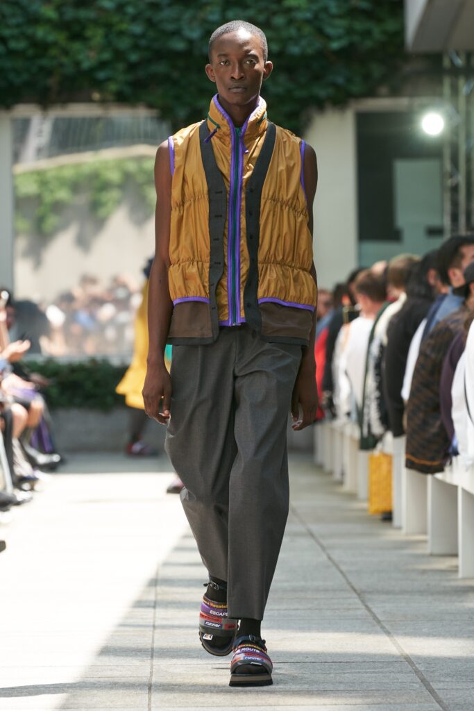 yellow padded vest with gray pants