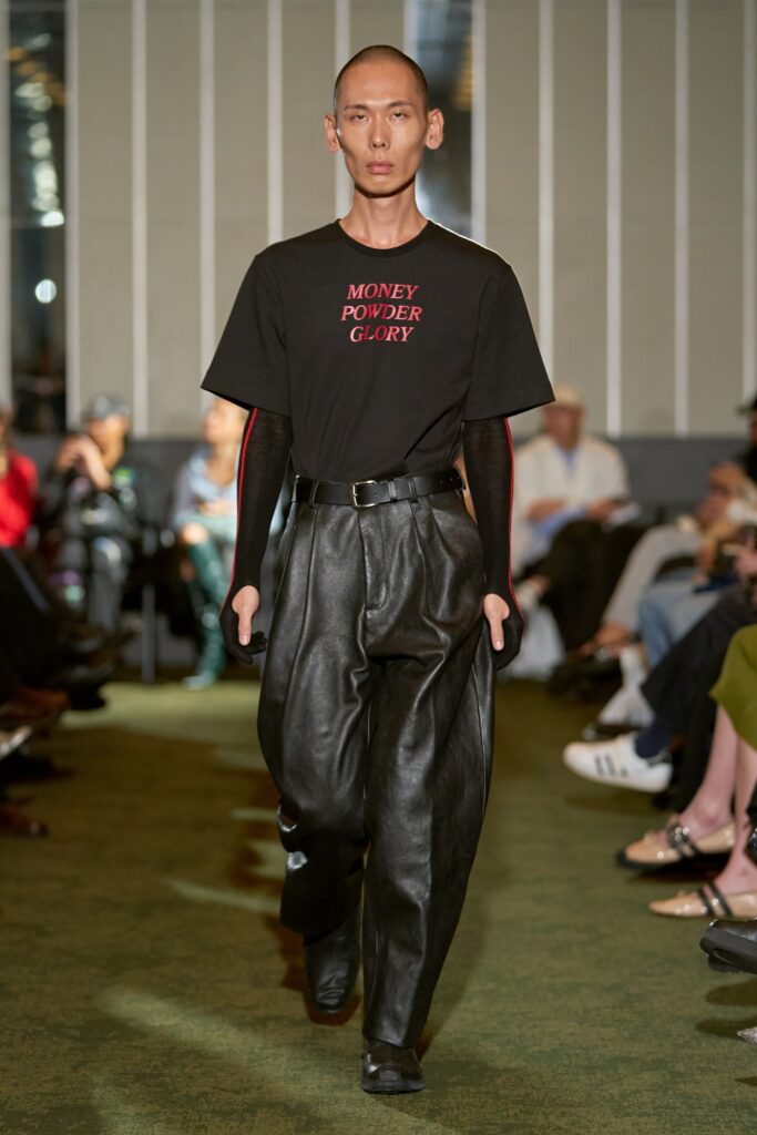 A relaxed black shirt with a printed design paired with wide-leg black pants.