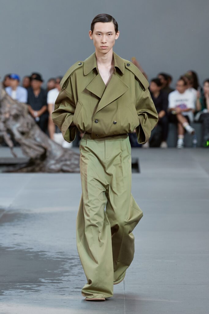 A relaxed green jacket with long sleeves and a collared neckline paired with wide-leg pants.