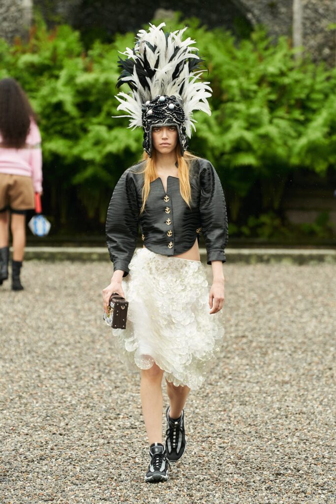 A fitted black cropped top with long sleeves paired with a layered ruffled white skirt.