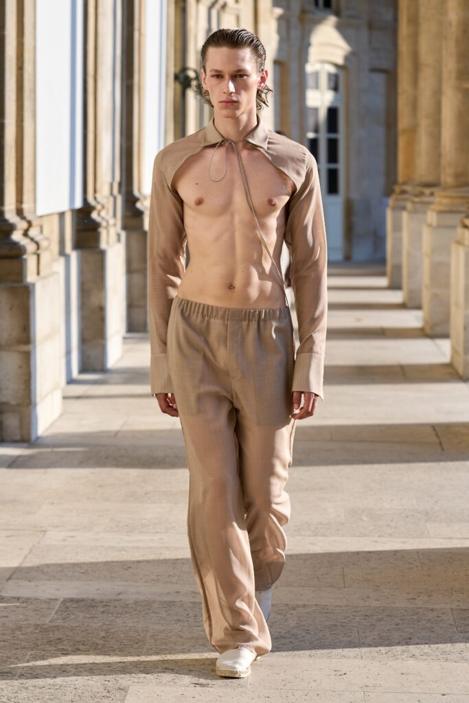 A fitted beige long-sleeve shirt with a collar paired with straight-leg pants.