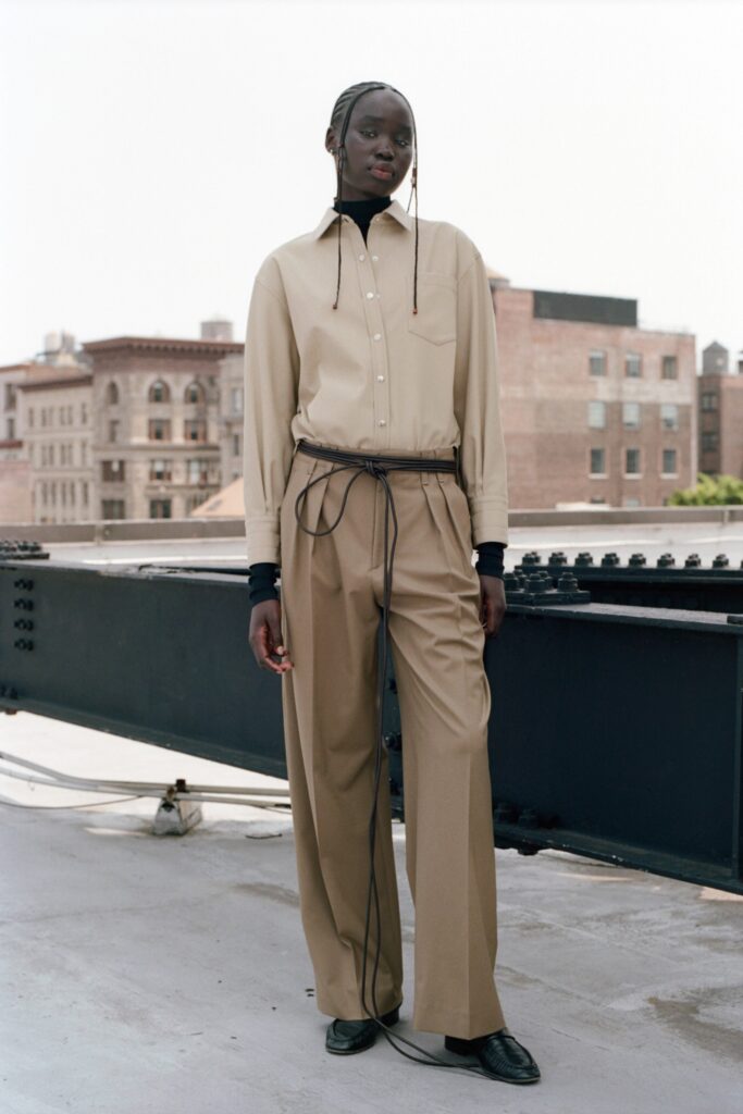 A relaxed beige long-sleeve collared shirt paired with straight-leg pants.