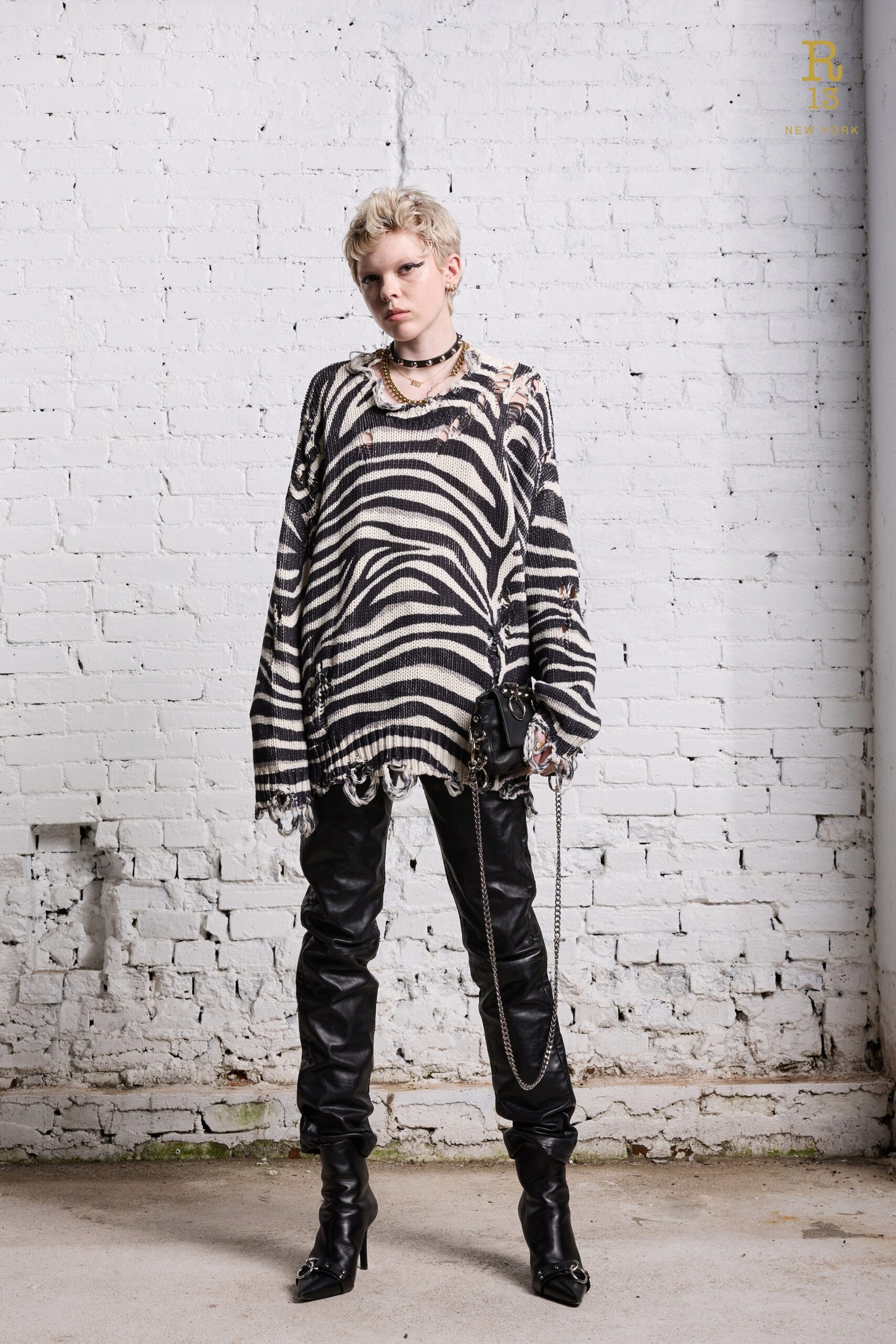 An oversized black and white striped sweater paired with fitted leather pants.