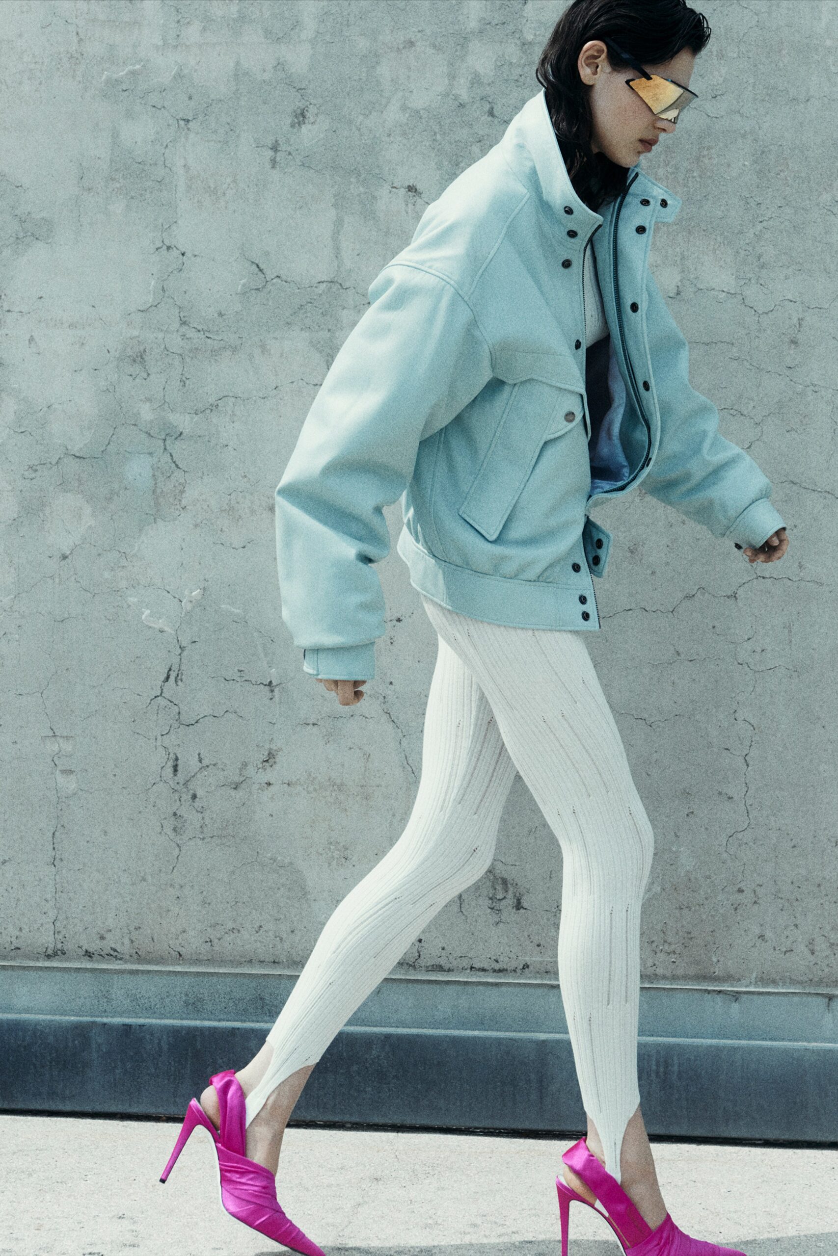 A fitted blue cotton jacket paired with white leggings featuring a zippered detail.