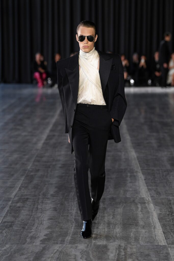 A fitted black blazer over a white collared shirt paired with tailored pants.