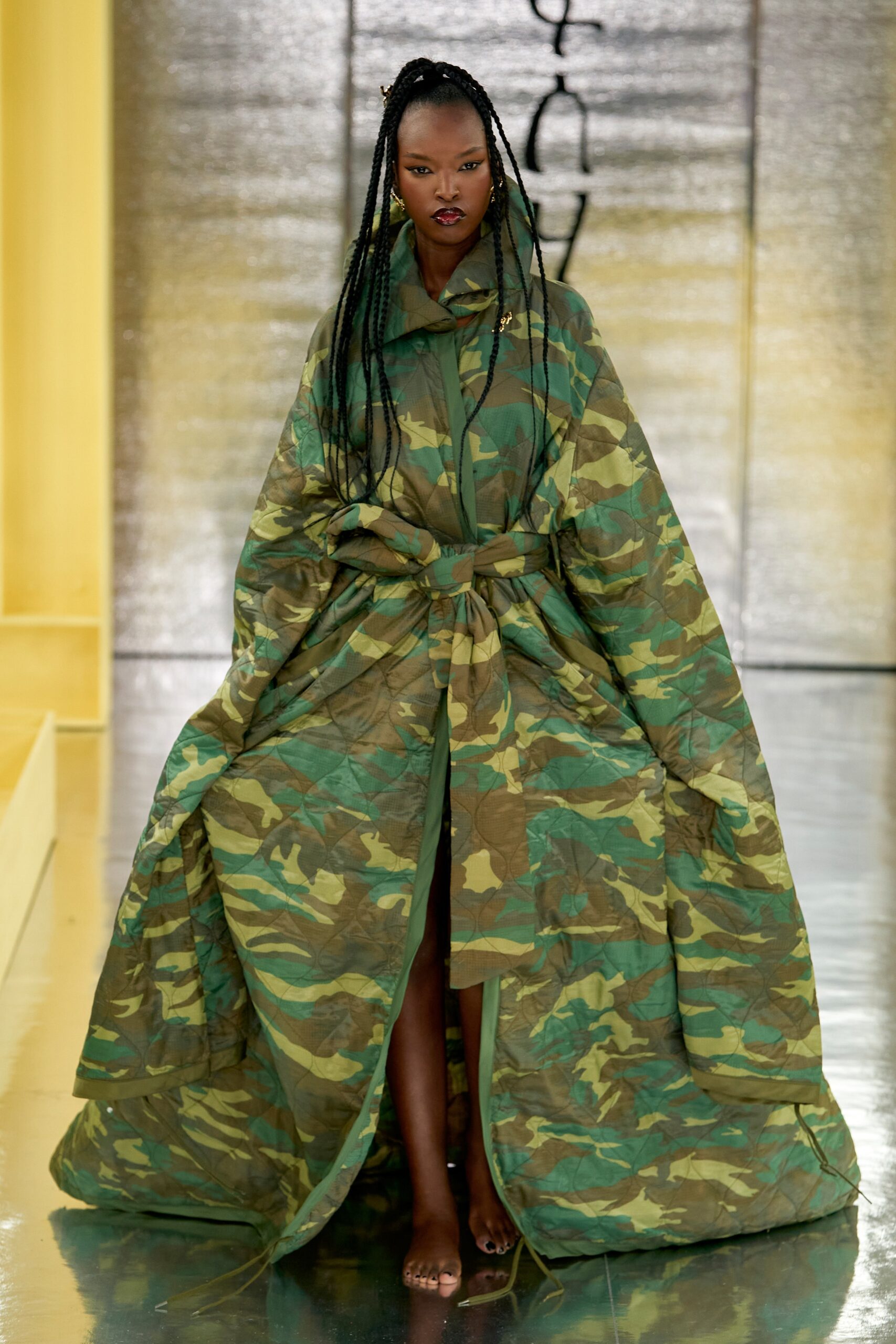 A relaxed green cotton cape with a belted waist and asymmetric design.
