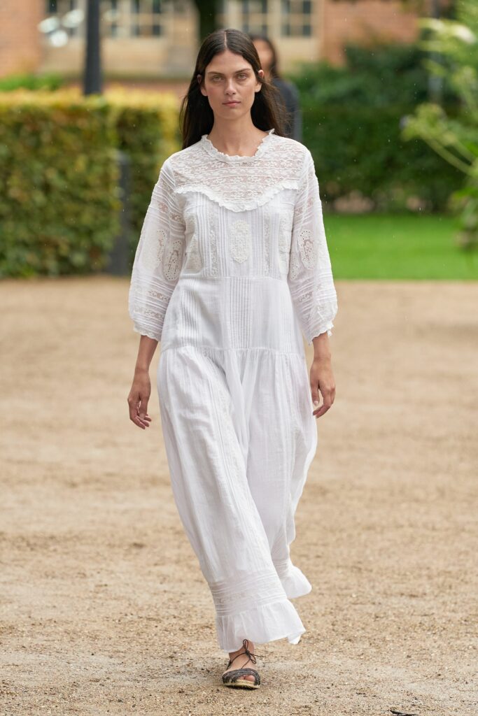 A relaxed white dress with long sleeves and intricate embroidery details.