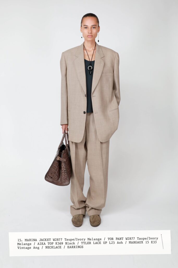 A relaxed beige jacket with long sleeves and collared design paired with straight-leg pants.