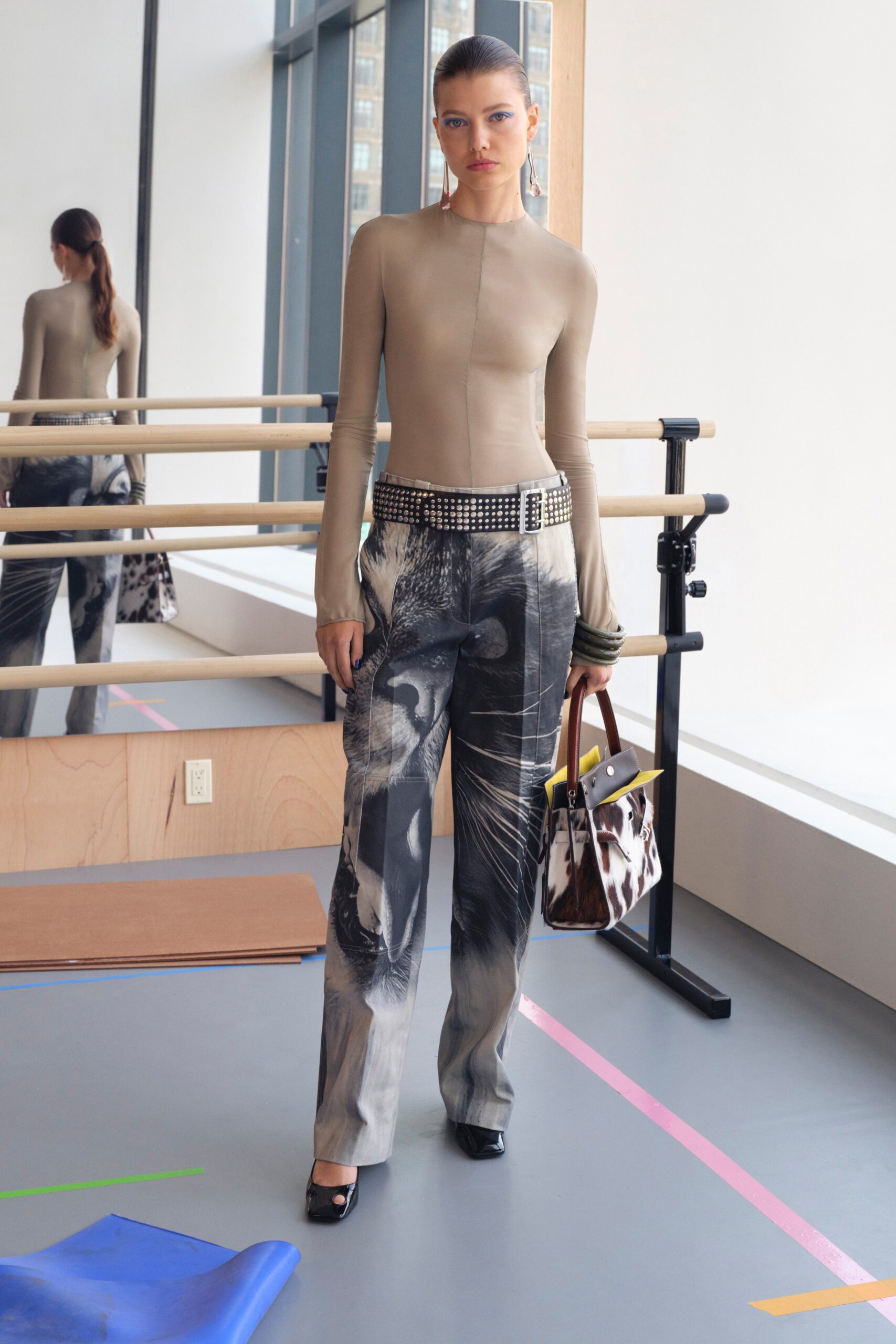 A fitted beige long-sleeve top paired with printed straight-leg pants for a stylish look.