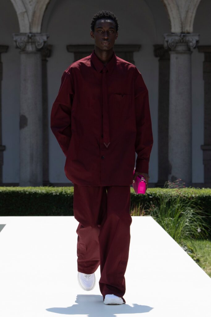 An oversized burgundy cotton shirt with long sleeves and straight-leg pants.