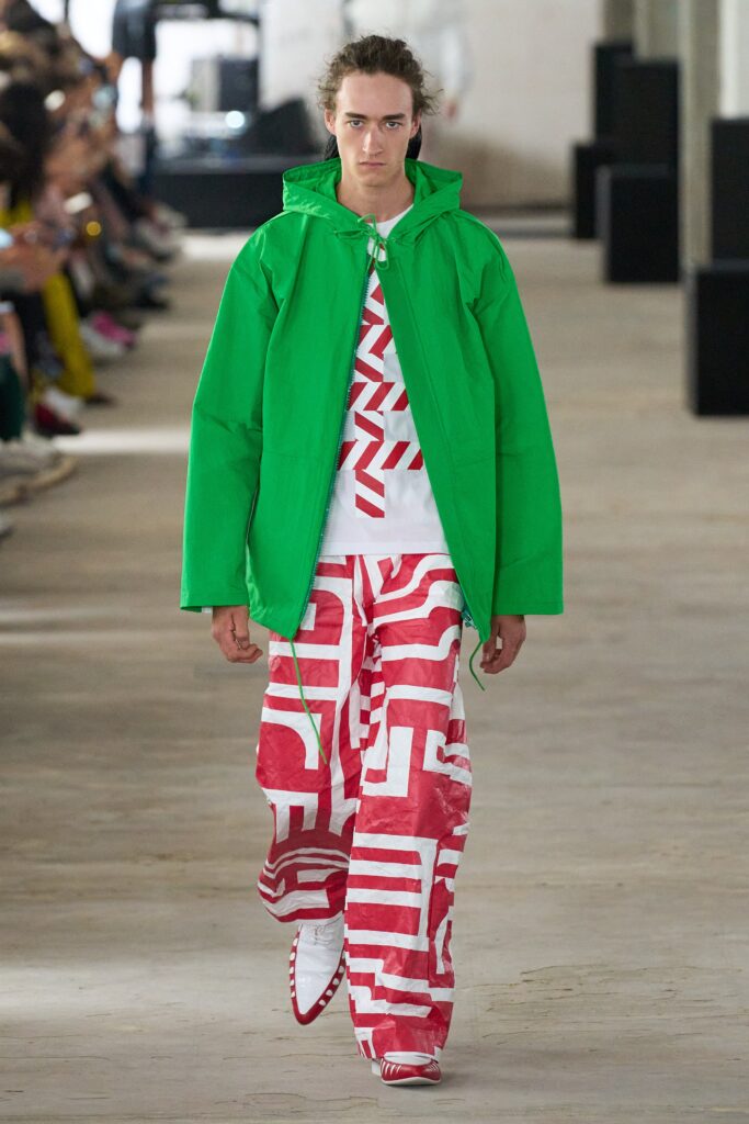A relaxed green jacket paired with printed pants featuring a bold design.