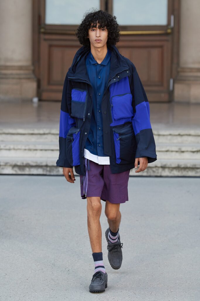 A relaxed fit color-blocked jacket paired with purple shorts, featuring a collared shirt underneath.