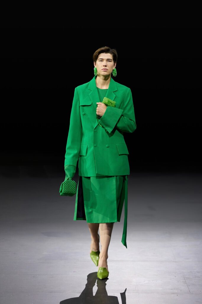 A tailored green blazer paired with an asymmetric green skirt, creating a bold fashion statement.