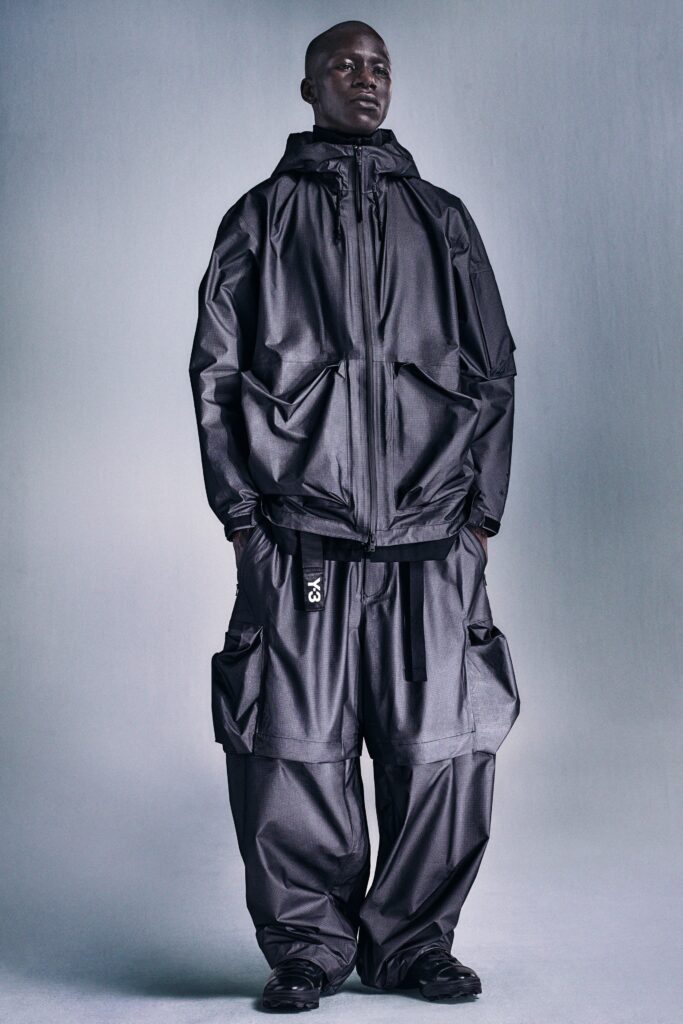 A relaxed black denim hooded jacket paired with matching pants featuring zippered details.