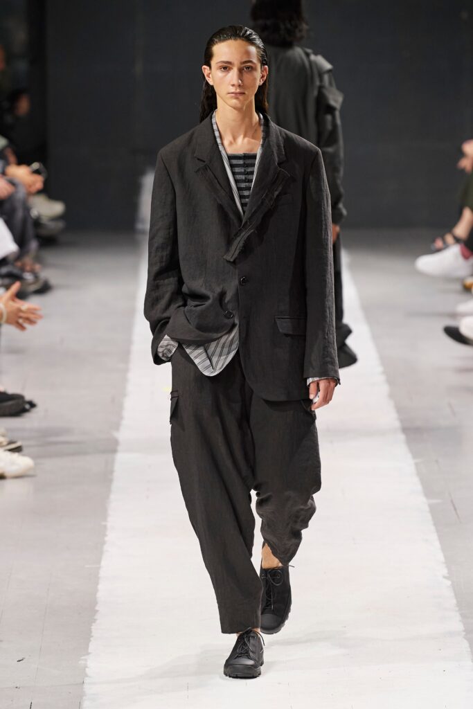 A relaxed black jacket with long sleeves and collared design, paired with wide-leg pants.