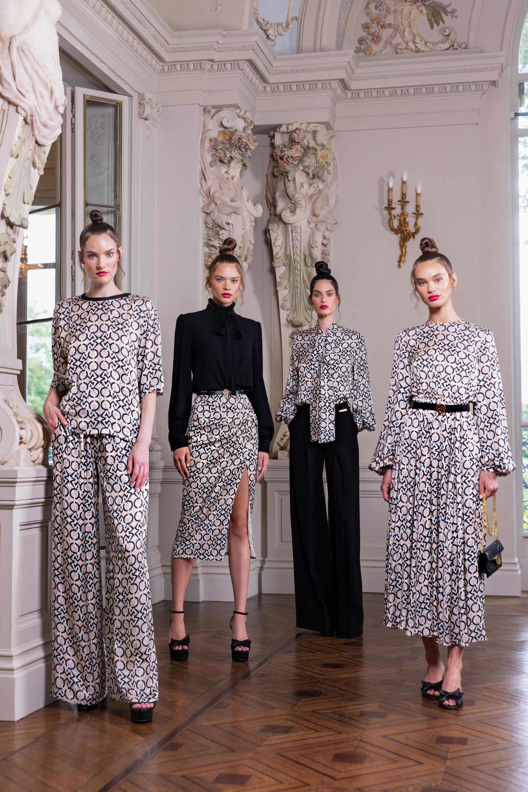 A fitted black and white printed dress with long sleeves and a slit detail.