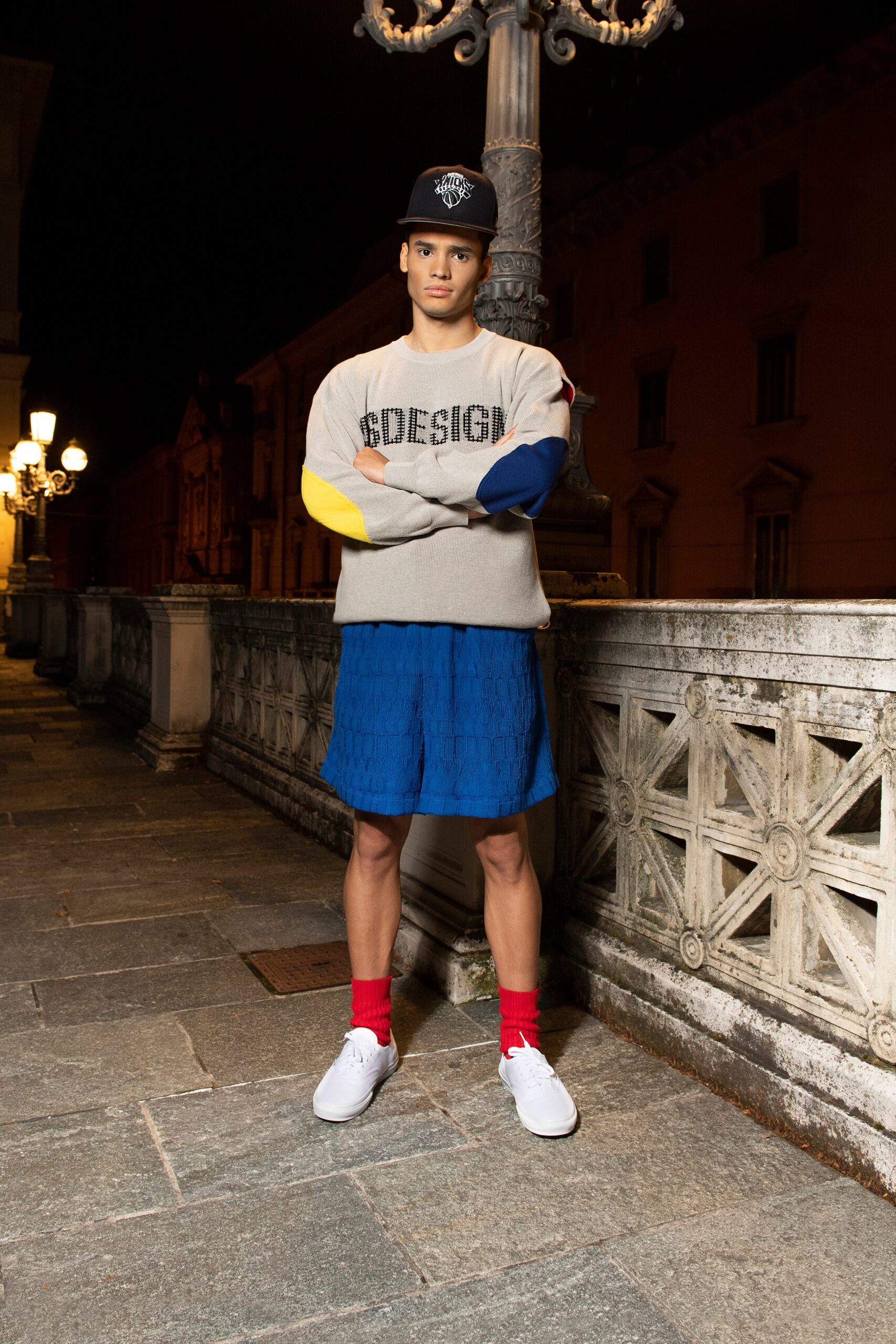 A relaxed gray printed sweater paired with blue shorts for a casual look.