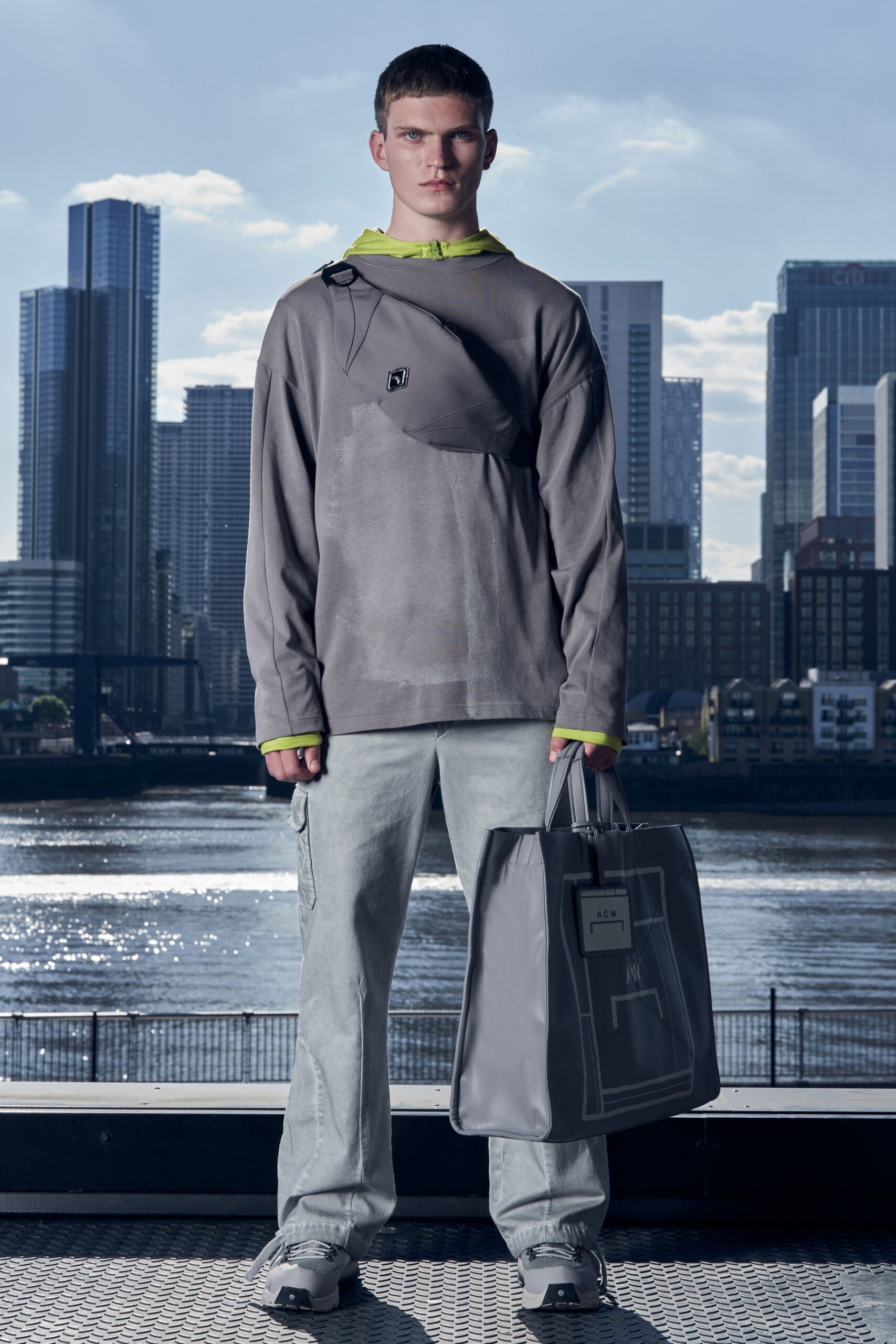 A relaxed gray long-sleeve hooded top paired with denim pants, featuring a layered look.