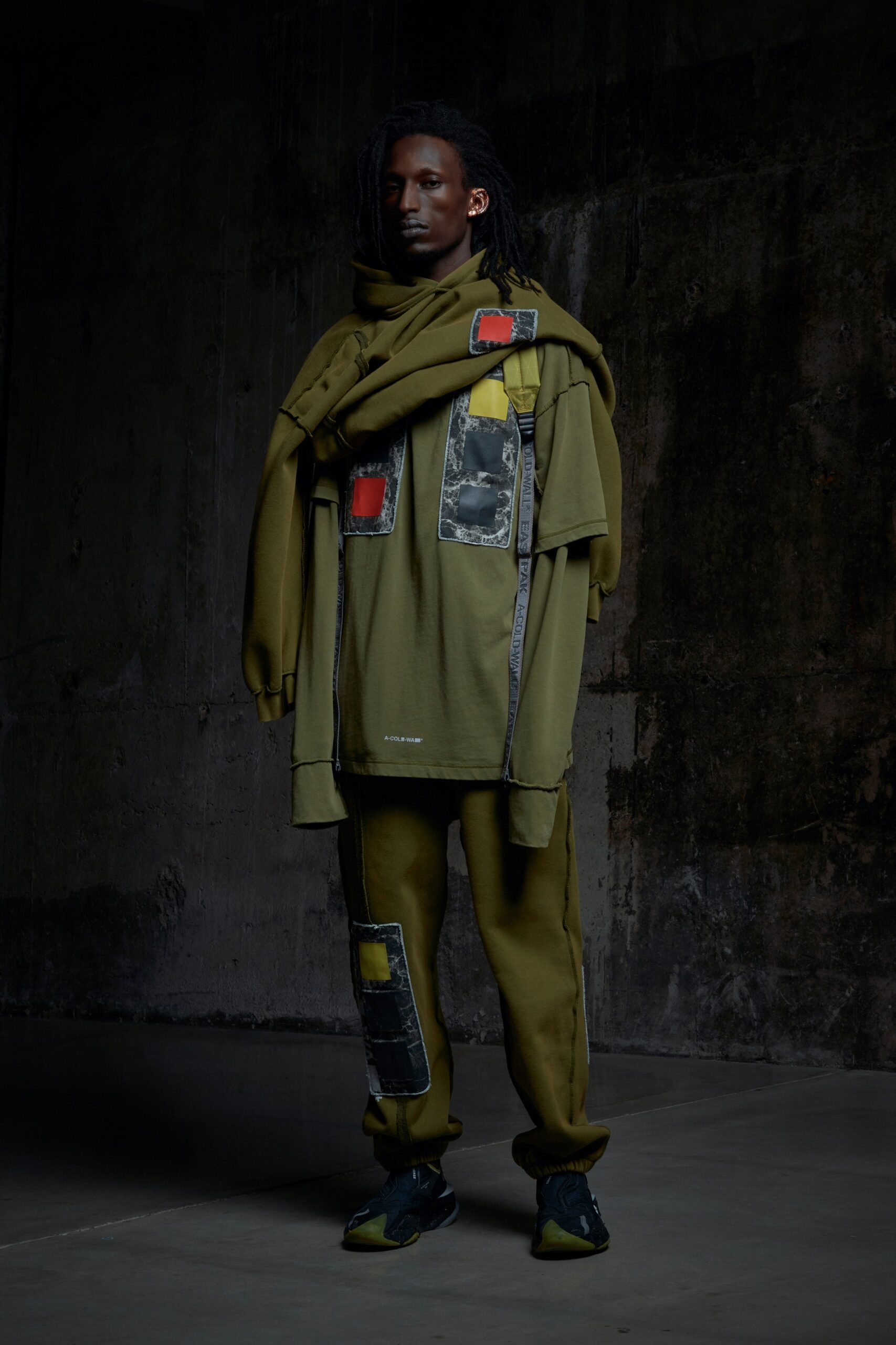 A relaxed green cotton long-sleeve top paired with matching relaxed pants featuring layered design details.