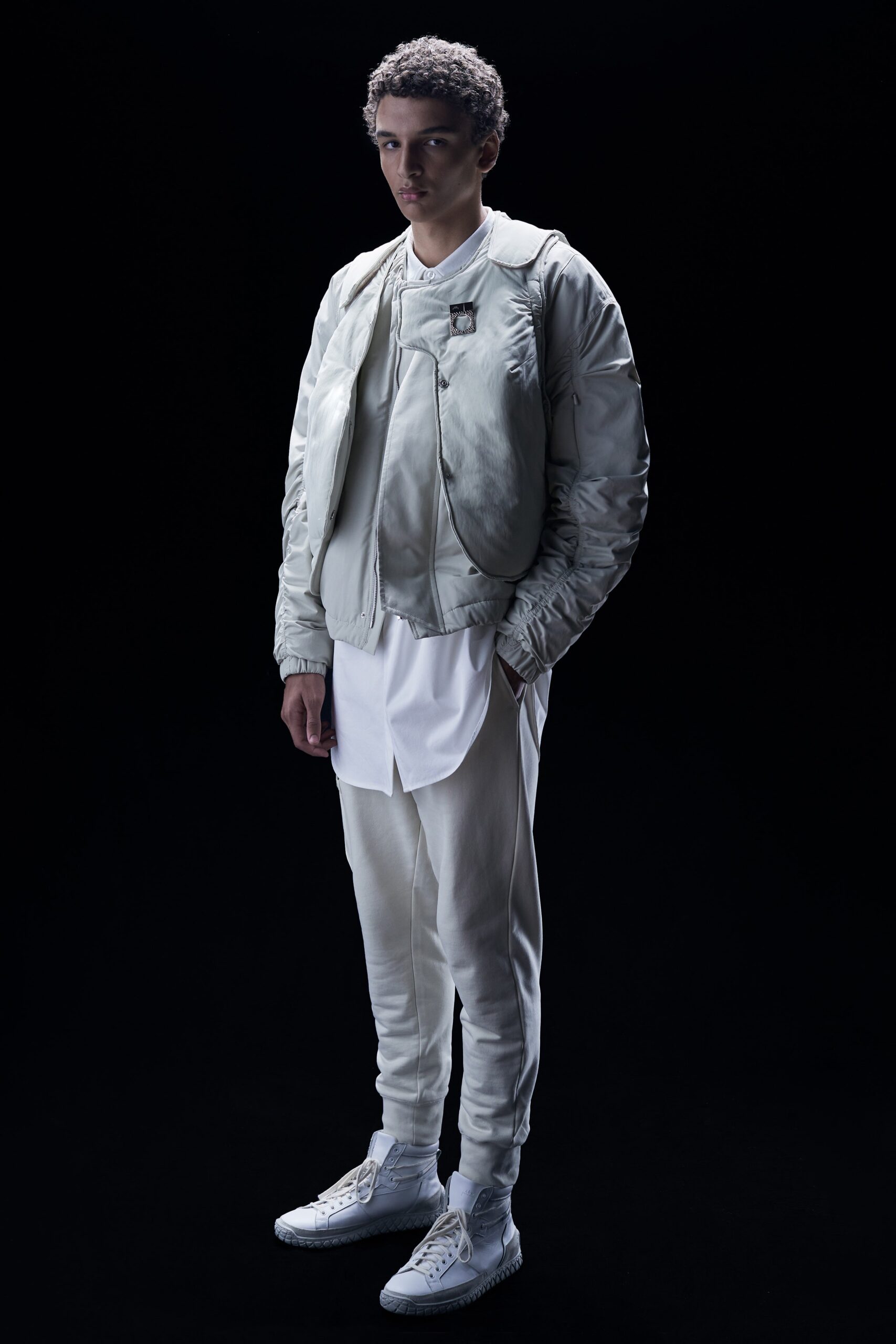 This fitted jacket features a contemporary silhouette with a structured collar and long sleeves, complemented by zippered details that enhance its modern aesthetic. Paired with matching pants, the ensemble creates a cohesive look that balances form and function.