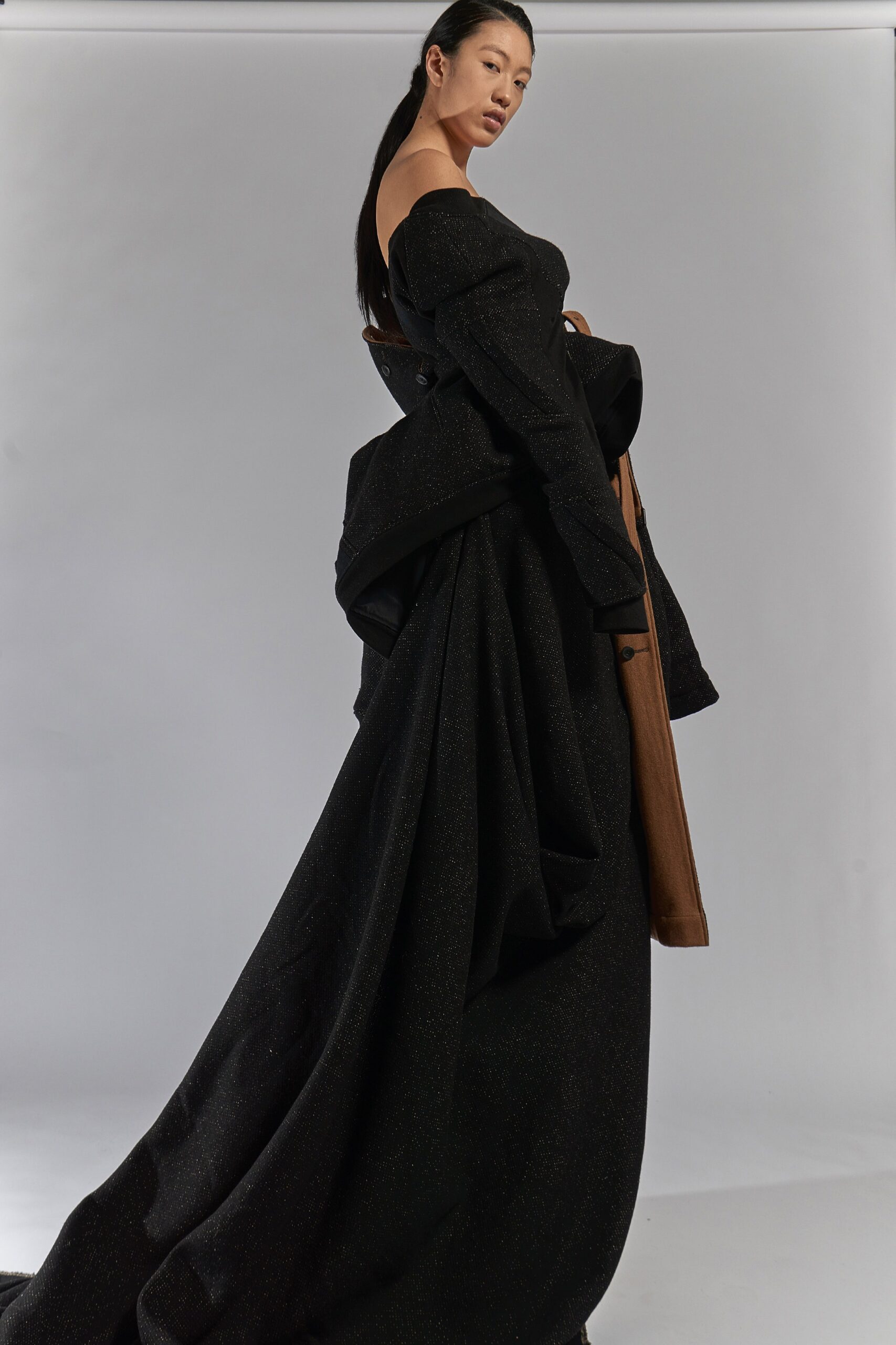 black silk off-shoulder gown with brown coat