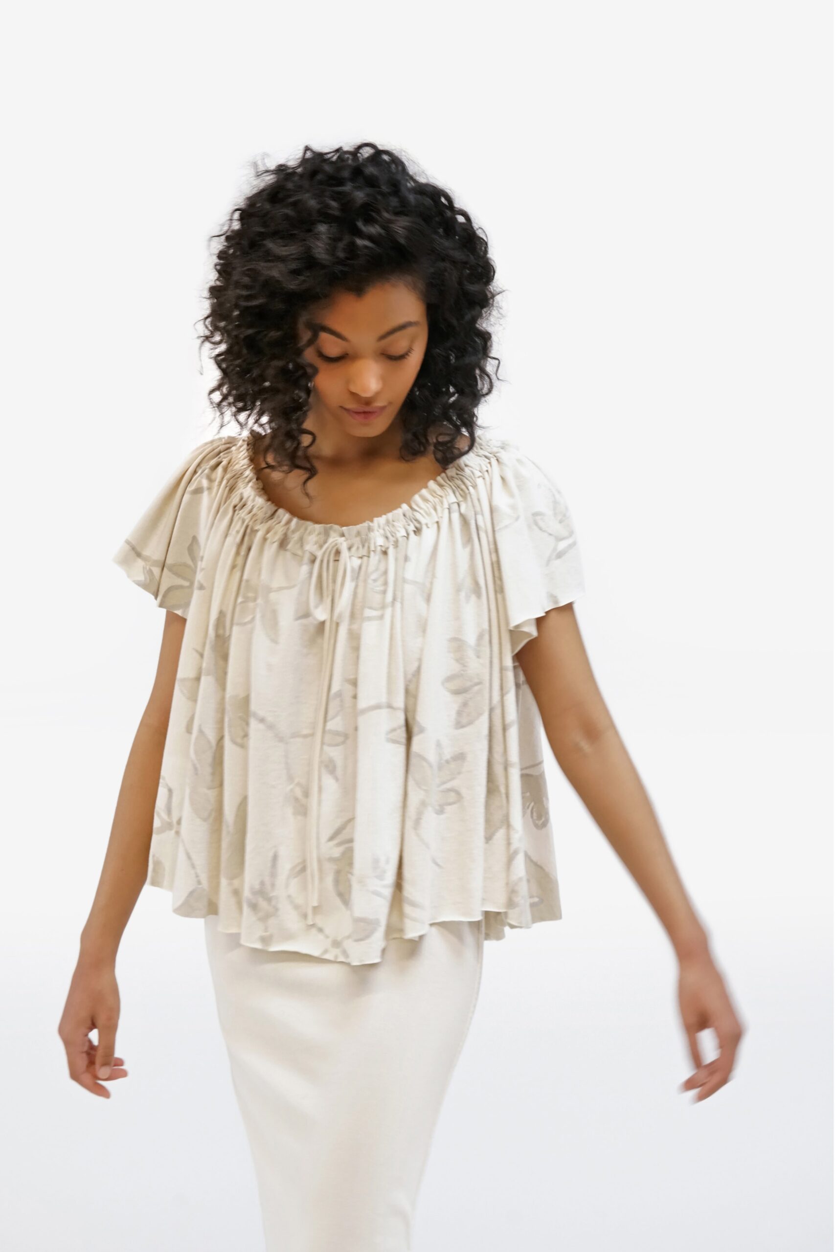 beige pleated top with white dress