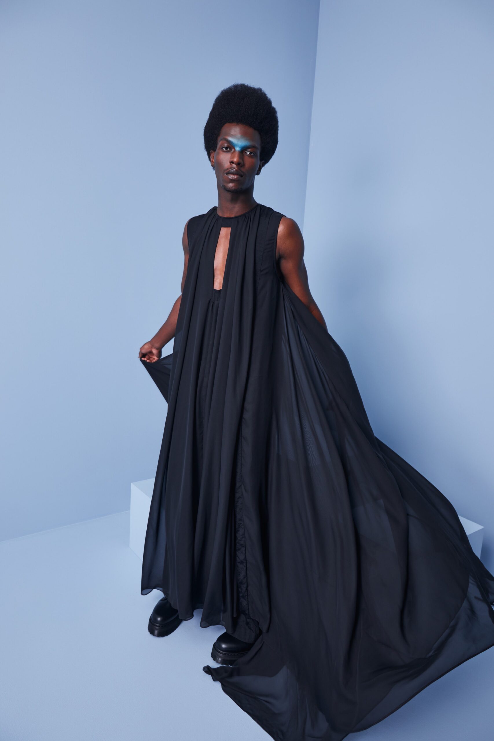 This relaxed sleeveless dress in black silk flows gracefully, creating an ethereal silhouette. The deep V-neckline adds a striking focal point, while the layered design enhances movement and depth, inviting a sense of fluidity.