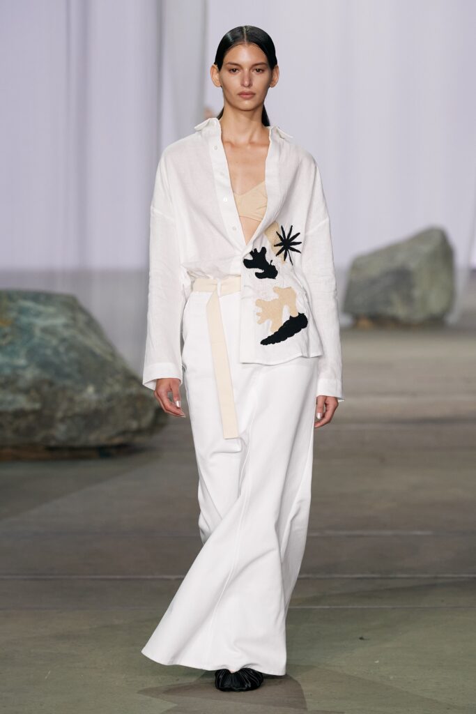 A relaxed white long-sleeve shirt with a collar and printed design paired with matching pants.