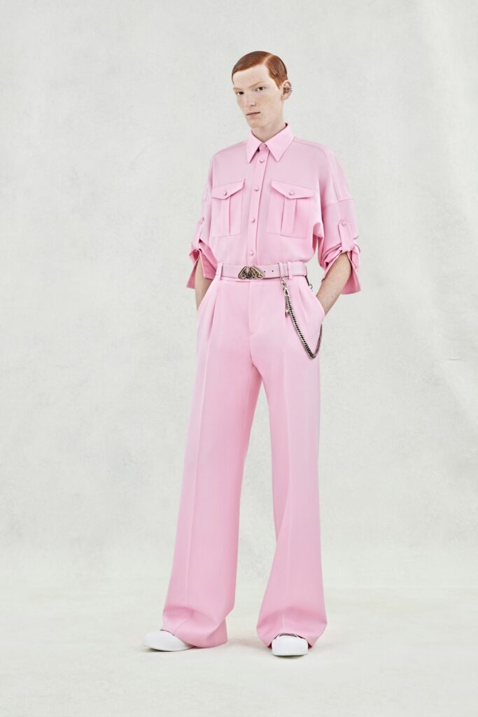 A relaxed pink shirt with short sleeves and a collared neckline paired with wide-leg pants.