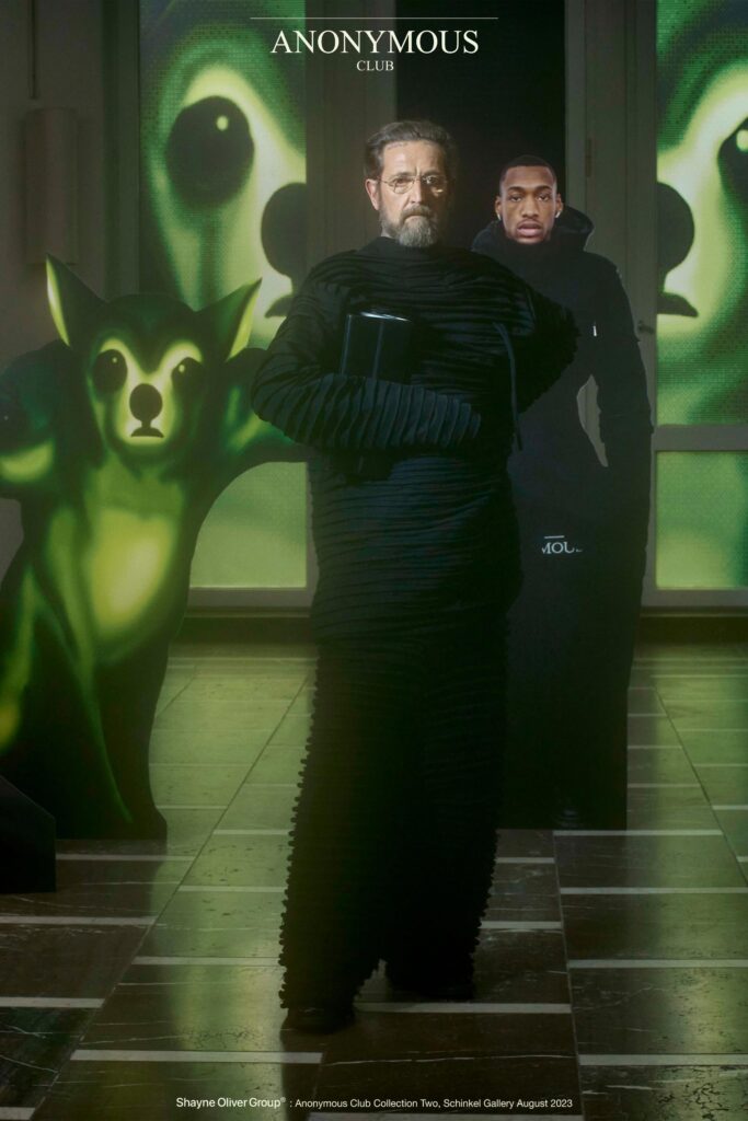 A relaxed black cotton coat with long sleeves and a layered design.