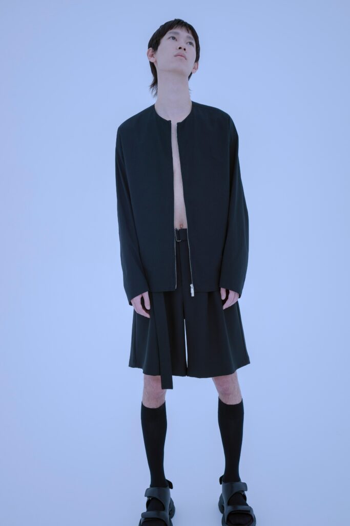 A relaxed black jacket with long sleeves and asymmetric shorts for a modern look.