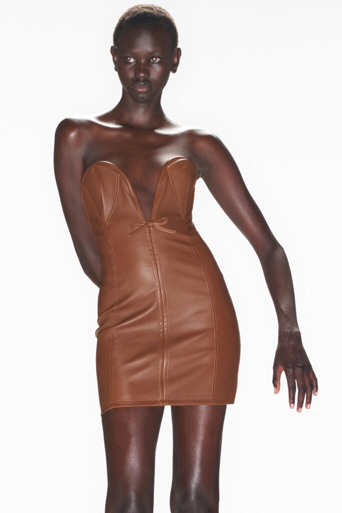 A fitted brown leather strapless dress with a V-neckline and pencil silhouette.