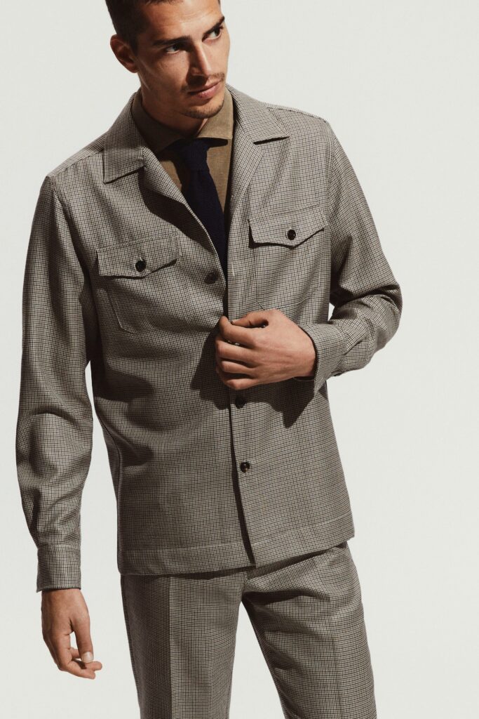 A fitted gray checked jacket with long sleeves and a collared design, paired with matching pants.