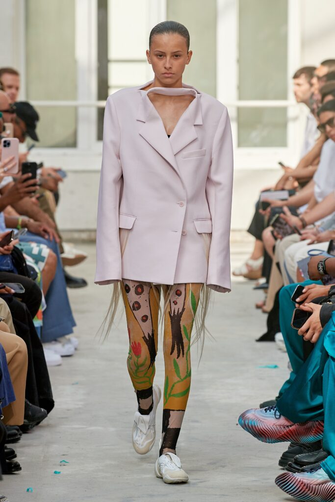 An oversized pink jacket paired with multicolored printed leggings for a bold runway look.