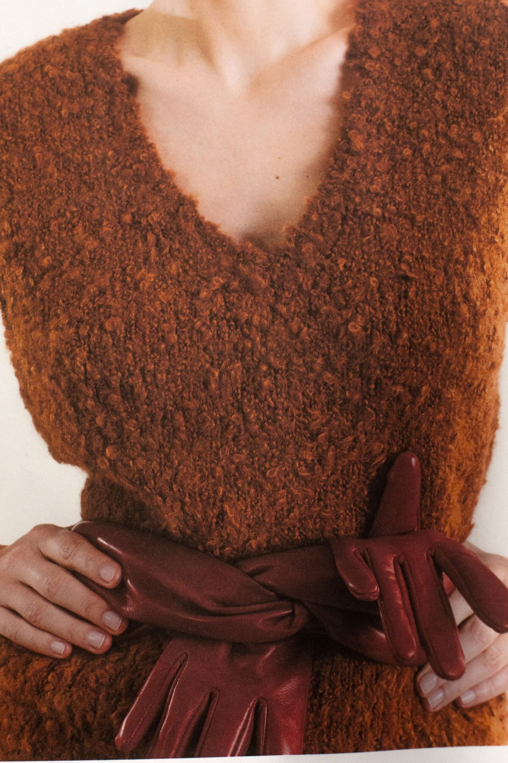 A relaxed orange wool top with a V-neckline and textured finish.