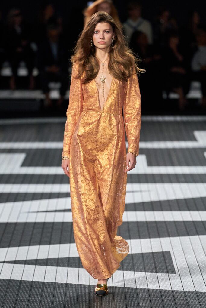 A relaxed orange silk long-sleeve dress with a deep V-neckline and embroidered details.