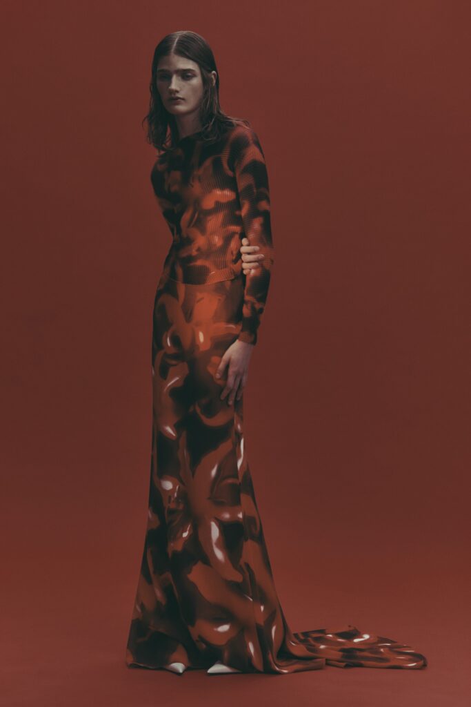 A fitted long-sleeve red and black printed maxi dress with a high neckline.