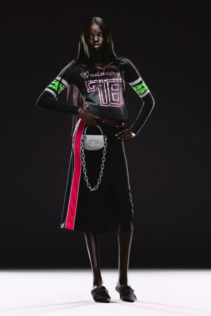 A fitted black dress with short sleeves, a V-neckline, and an asymmetric color-blocked design.